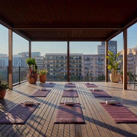 Rooftop yoga deck with mats and city skyline view in Barcelona
