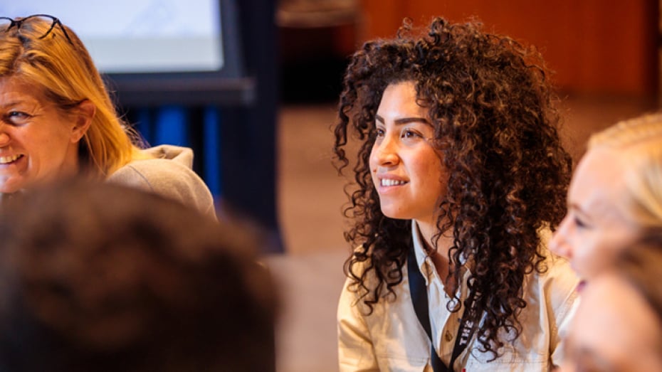 Smiling woman sitting in a masterclass brainstorm session