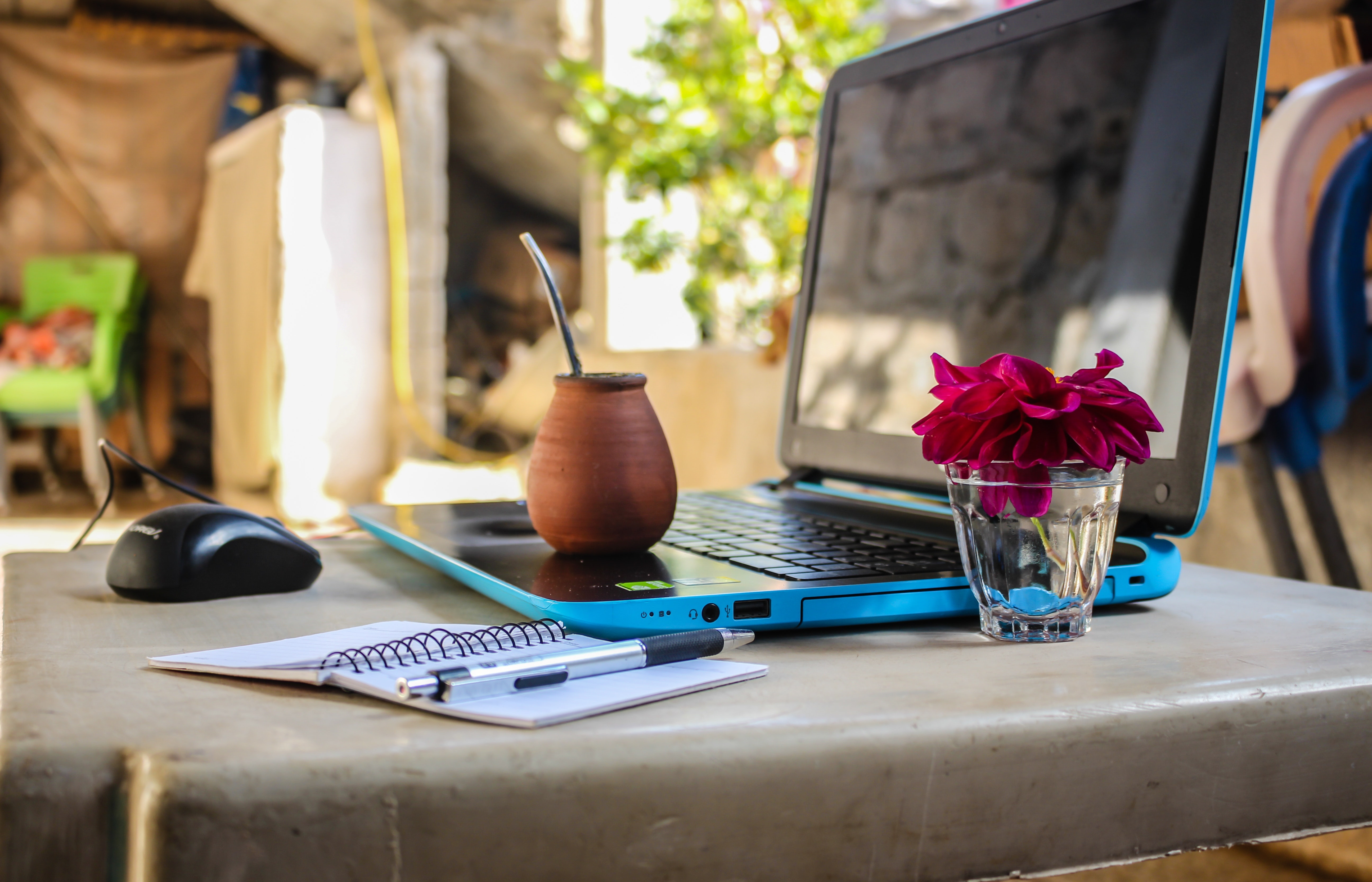 White notebook beside blue laptop computer.