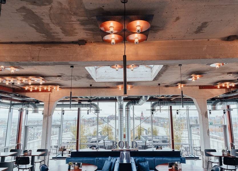 Exposed ceiling and floor to ceiling windows with panoramic city view at Bold bar at TSH Maastricht