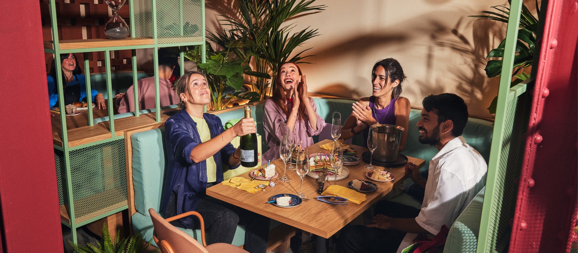 Guests celebrating with champagne and cake at The Social Hub restaurant