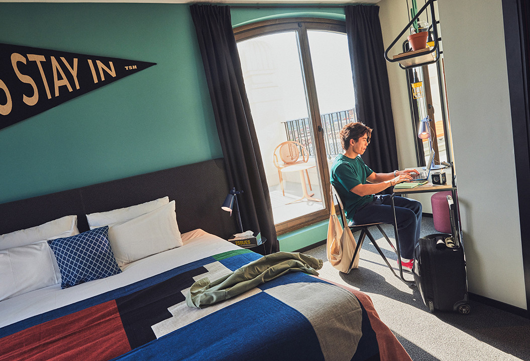 Guest working on the laptop in his room at The Social Hub